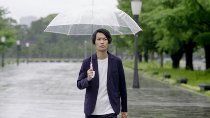 雨の日に傘を差して出かける男性　手持ち撮影