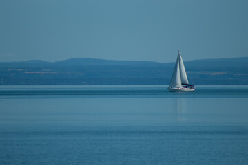 Sailboat On the Sea With Distant Mountains