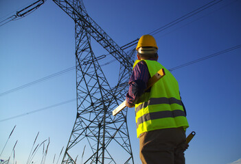 Engineer during power line inspection. Electrician at work. Production and supply of energy from...