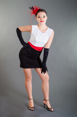 beautiful young slim girl in black and white dress with red belt and long black gloves