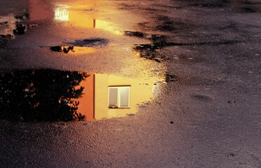 Window reflected in a puddle at sunset. © Marcin Olszewski 