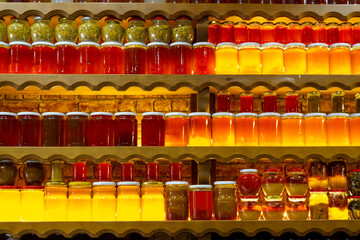 Honey varieties in jar on shelf