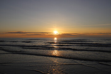 Obraz premium View of a beautiful sunset with beautiful colors over the sea with reflecting sun.