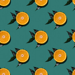 Colorful fruit seamless pattern of halves of oranges with green leaves isolated on green background. Top view