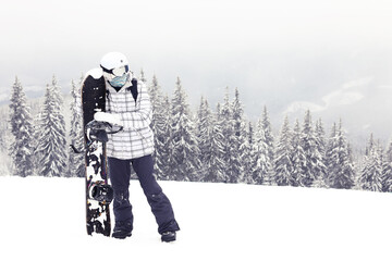 Fototapeta na wymiar man standing on mountain and holding snowboard in winter season 