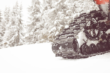 Details snowmobile in forest cover snow in winter 