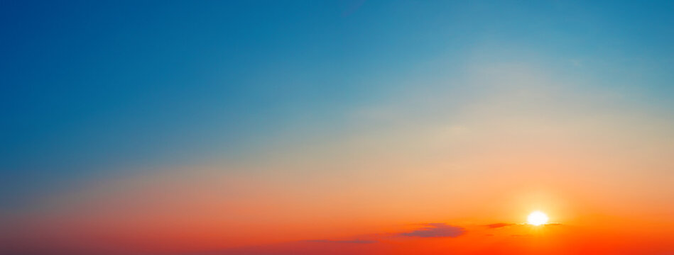 Panorama of dramatic sunset sky with setting sun