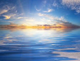 Naklejka na ściany i meble Sunset sky with sunbeams over water surface