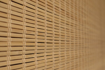 Light brown bamboo blind partly blurred