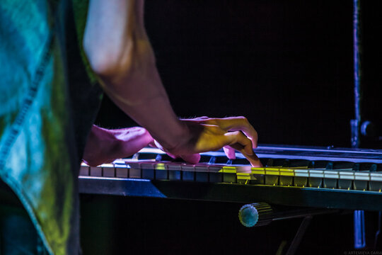 Boy's hands on keybord in flecs of yellow light
