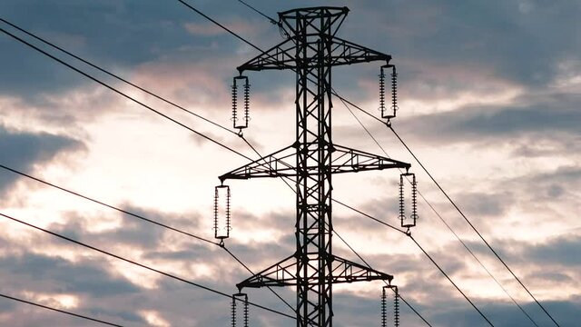 Mast of high voltage wires against the background of the movement of clouds. A structure for holding, attaching and suspending electrical wires at a certain level.