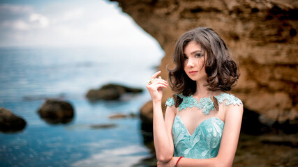 Beautiful young girl in a dress with butterflies on the beach. Portrait