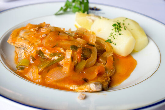 Traditional  seafood dish from Madeira cuisine - stewed scabbardfish in red vegetable sauce served with boiled potatoes