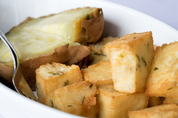 Traditional back side dish of Madeira cuisine - sweet potato (batata) slices baked in the oven with herbs