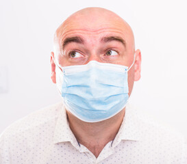 portrait of bald adult elderly man in medical mask with emotions on white background