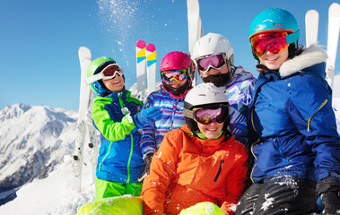 Group of ski school children have fun with snow on the mountain top