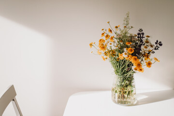 Colorful midsummer bunch of wildflowers. Bouquet of wild natural flowers in a vase on the table, selective focus. Summer wallpaper