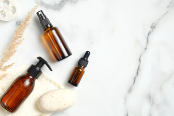SPA cosmetic dark amber glass bottles and homemade soap on marble background. Natural organic beauty products concept. Beauty blog banner mockup, minimal style. Flat lay, top view.