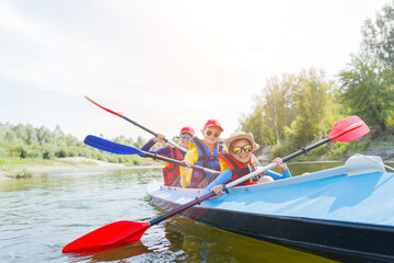 Happy boy kayaking on the river on a sunny day during summer vacation