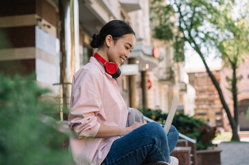 Asian freelancer using laptop, typing on keyboard, blogging. Portrait of beautiful woman copywriter...