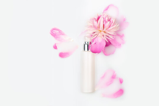 Natural cosmetics, mock up. Jar of cream and pink peony in a milk bath. Conceptual photo: the best cosmetic tool for body and face care. Gentle care. Copy space, flat lay.