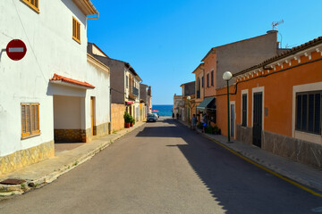 Fototapeta na wymiar Light street, leading to the coast of the sea with blue bright sky