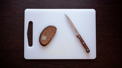 Moldy bread on a cutting board.