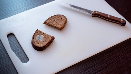 Moldy bread on a cutting board.
