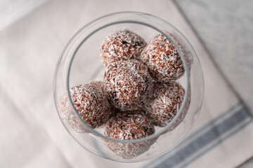 Date sweets with coconut shavings in a wine glass top view