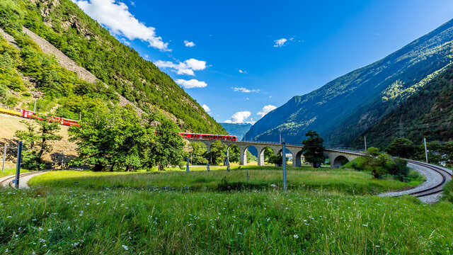 Train on the circular viaduct bridge near Brusio on the Swiss Alps