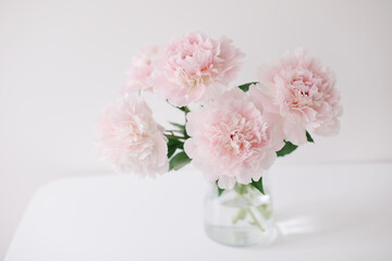 Obraz na płótnie Canvas Beautiful pink peonies in a vase at home interior. Flower composition. Floral shop concept. Beautiful fresh cut bouquet. copyspace