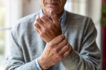 Senior man with arthritis rubbing hands
 - obrazy, fototapety, plakaty