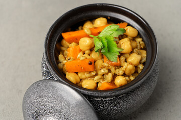 Vegetarian pilaf gray in a pot decorated with greenery close-up