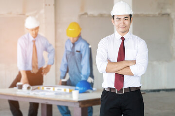 Portrait of handsome engineer with construction site background.