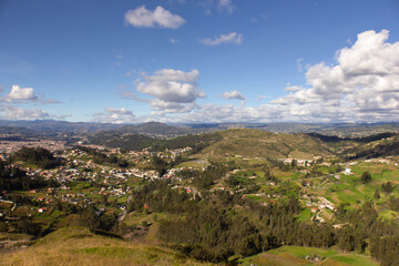 Fototapeta na wymiar panoramic view of a town between a landscape of forests and mountains on a sunny day with little cloudiness