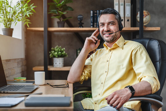 Portrait Of Mature Man Wearing Headset Working For Call Center