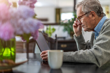 Senior man working on laptop at home
