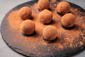 Round candy made of dates and carob on a slate Board