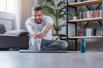 Handsome adult man doing fitness exercise at home
