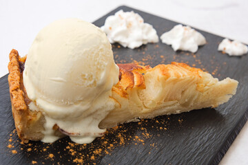 A piece of delicious homemade apple pie served with sweet vanilla ice-cream