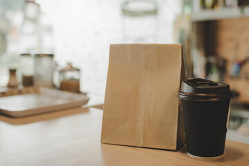 hot black coffee cup and dessert paper bag waiting for customer on counter in modern cafe coffee shop, food delivery, cafe restaurant, takeaway food, small business owner, food and drink concept
