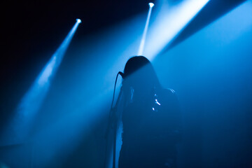 Metal singer silhouette in dark with blue lights