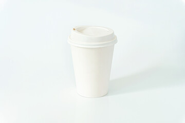 White disposable paper coffee cup with plastic lid isolated on white background