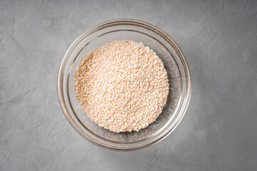 Sesame seeds in a glass dish on a concrete table top view