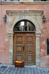 Fototapeta na wymiar Old European style door with a basket of oranges in Chania, Crete