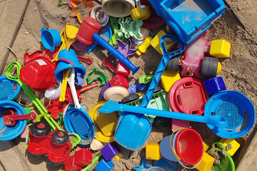 a bunch of plastic toys thrown in a sandbox