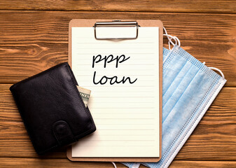 PPP Loan Salary Protection Program. Paper on a wooden table near the wallet