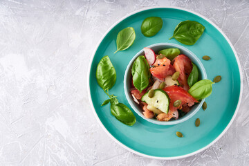 Healthy food. Mix salad of fresh summer vegetables in bowl, fresh basil,tomato,onion,cucumber, sesame seeds
