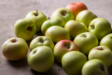 Many green apples are scattered on the table. Harvest. Fruits.