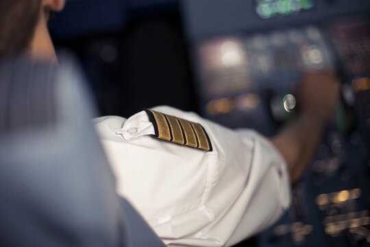 Young pilot in the aircraft in front of the dashboard. Pilot control airplane. Flight by commecial Airlines. Pre-flight preparation before the flight.Image with selestive focus.